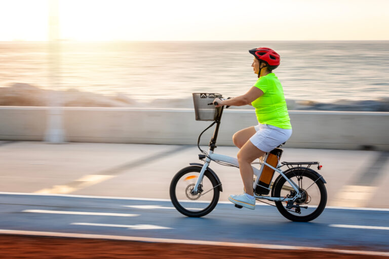ebikes for seniors. Mature woman riding electric bicycle outside. Cycling, also known as bicycling or biking, is the activity of riding a bicycle or other type of cycle.