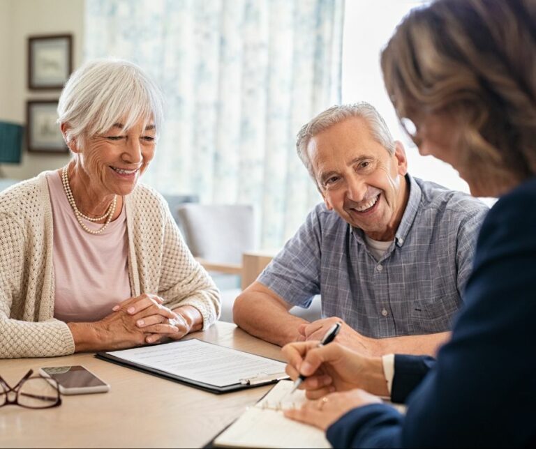 This image depicts a senior couple meeting with an advisor during Medicare Open Enrollment.