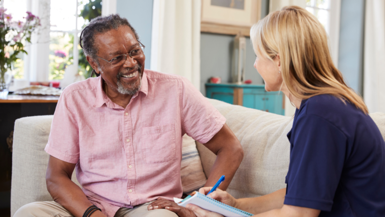 This image shows a senior man speaking with a woman. The image is meant to depict mental health treatment with a therapist.