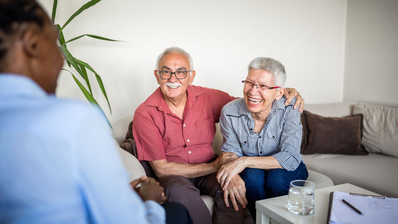 This image depicts a senior couple speaking with an advisor about Medicare Advantage vs. Original Medicare.